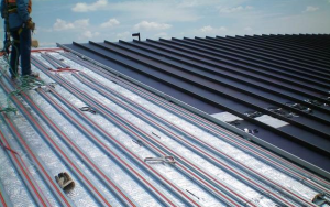 A building-integrated solar-thermal system was installed above the roof’s radiant barrier and below its new metal roof panels.