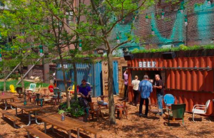 Vendors sell local beers and unique snacks out of old shipping containers; LED lighting strung through transplanted honey locust trees provides ambiance; and reclaimed pallets and rockers offer seating to patrons of the pop-up beer garden.