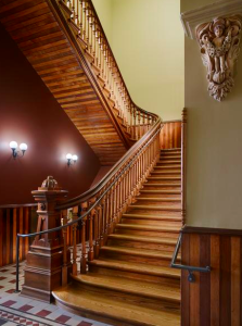 The building’s unsightly staircase is now a beautiful highlight. Contractors removed the original newel post, raised the element to the required code height, and restored and reinstalled the post along with the original curved top rail on new wood spindles.