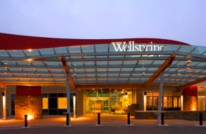 The curved red wall and glass canopy was added to “break” the box form and create a welcoming entry for Wellspring Medical Center.