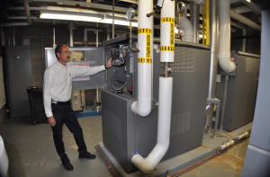 Facilities Director Rick Perkins surveys Robison Elementary’s boiler controls.