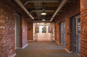 With the gymnasium addition extracted, the plan for Voke Lofts offered a courtyard entrance to the structure, walkways, views of green space and ample natural daylighting (vital to any residential project) to all floors, including the first.