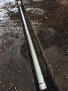 To mitigate vapor intrusion, trenches are cut into concrete to allow the removal of some soil and the placement of perforated collection pipes and sump fans with a pea-rock backfill.