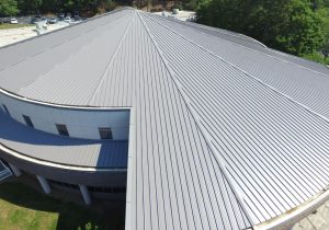 Installation of the standing seam metal panels is a challenge. All panels are measured and cut at an angle where it meets the hip.