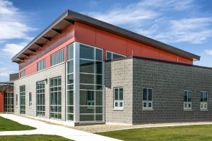 The color selection of the composite panels is driven by the colors of the existing buildings and hangars on site.