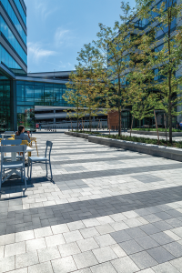 Unilock Umbriano pavers installed at a mixed-use office and retail development to create a programmable plaza that provides tenants with additional outdoor amenities.